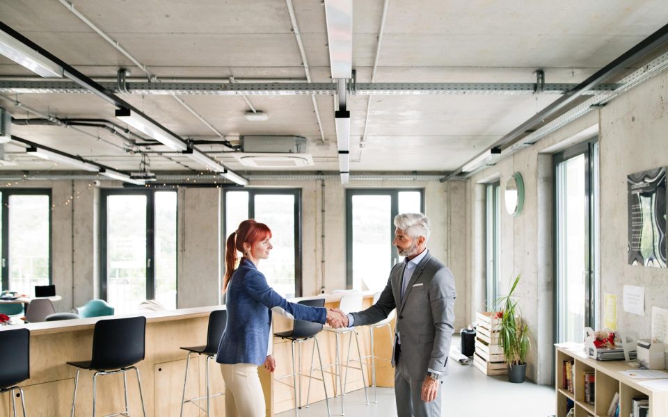 two-business-people-in-the-office-shaking-hands-PWRS4YC.jpg